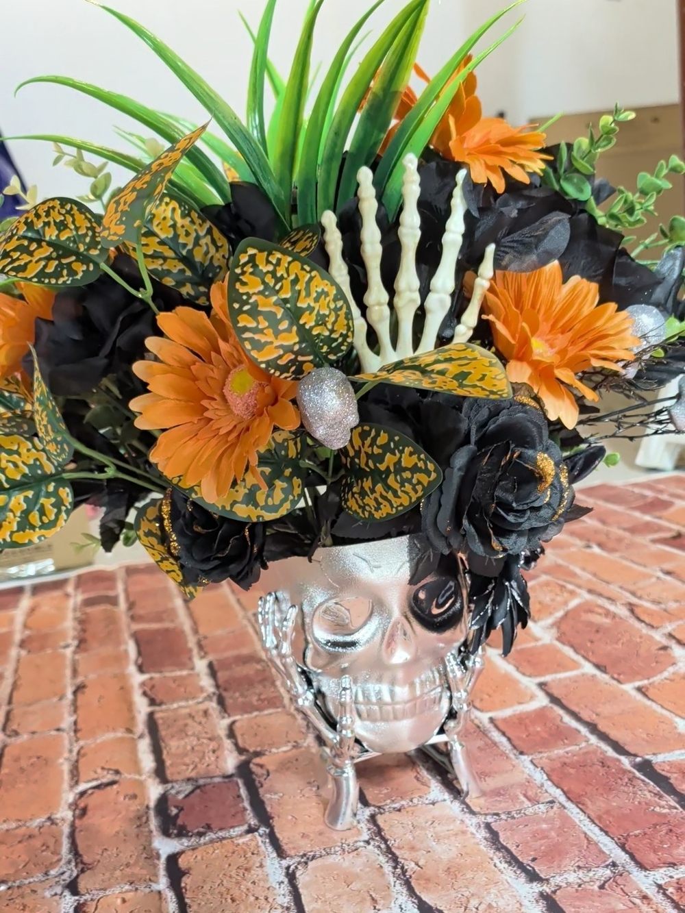 Hand Crafted Silver Skull Vase with Orange, Black and Green Faux Floral Mix